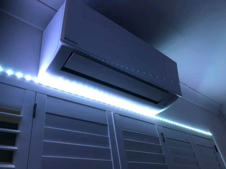 Wall-mounted air conditioning unit installed above a window