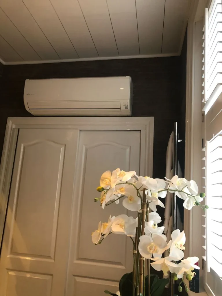 Air conditioning unit fitted above a fitted wardrobe in a bedroom