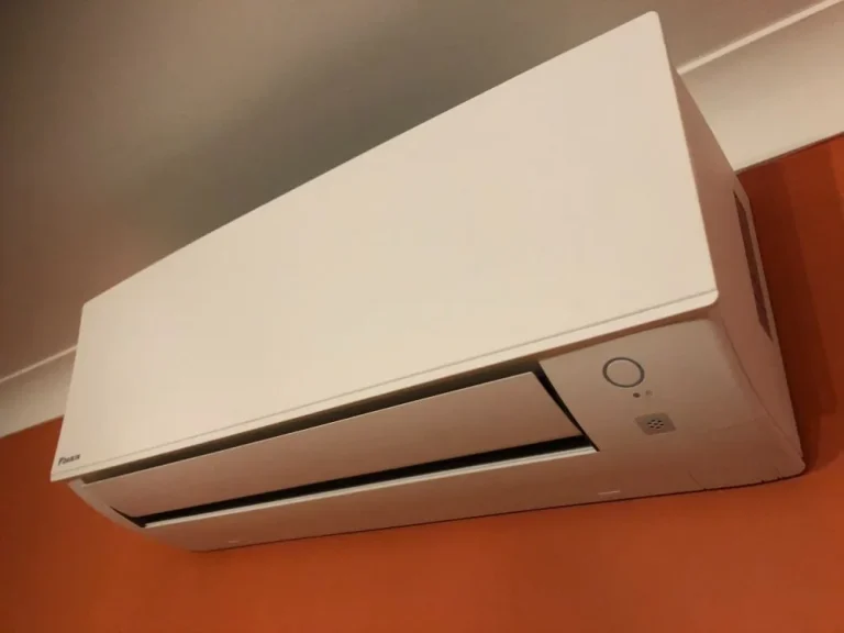 Wall-mounted air conditioning unit on an orange feature wall in a home